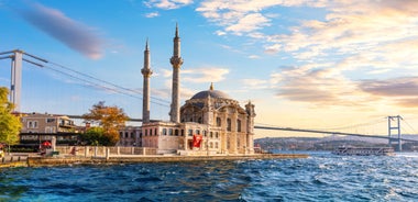 Touristic sightseeing ships in Golden Horn bay of Istanbul and mosque with Sultanahmet district against blue sky and clouds. Istanbul, Turkey during sunny summer day.