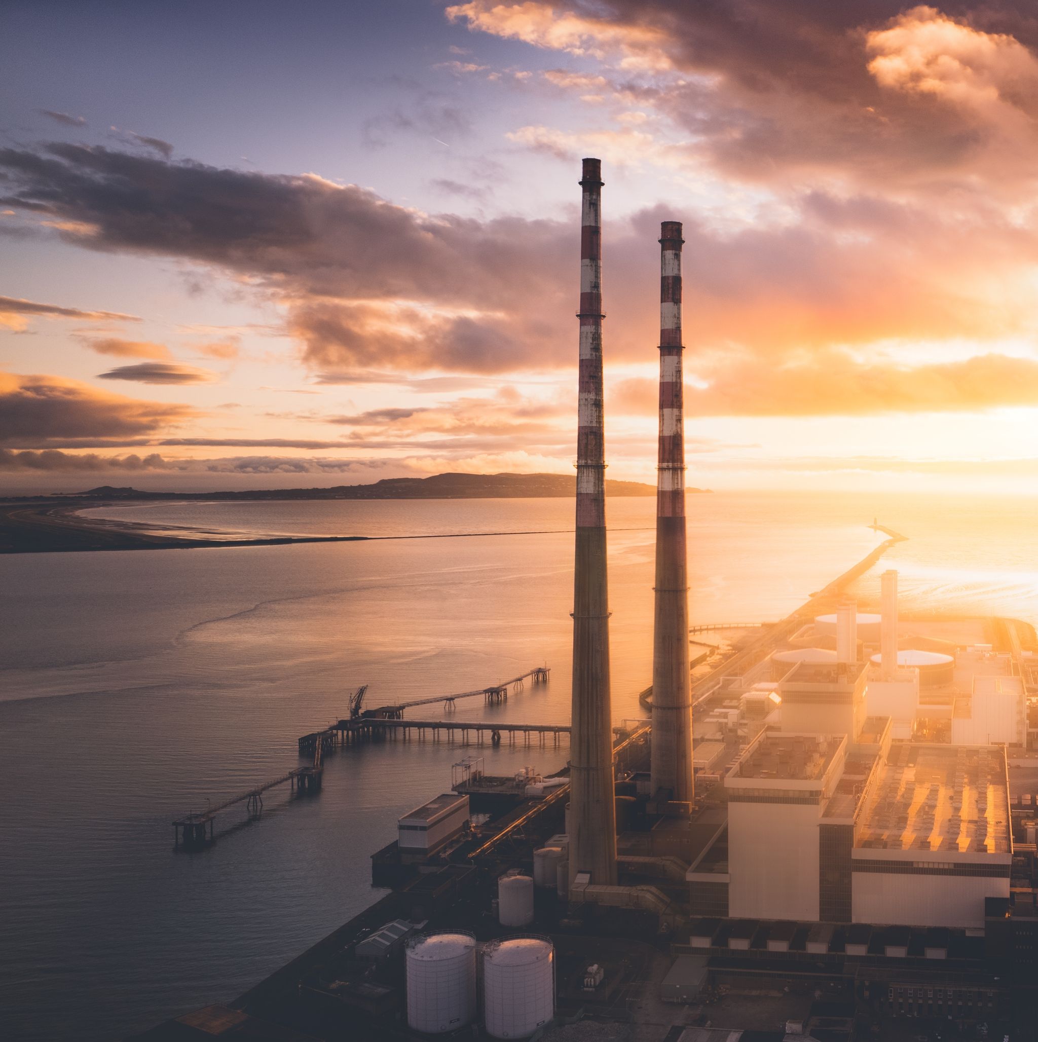 photo of view of Poolbeg Towers at sunrise with Poolbeg Lighthouse in the background, Dublin, Irland.