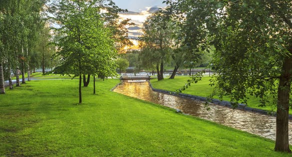 Photo of beautiful sunset with sun reflection in Oulujoki river in Oulu, Finland.