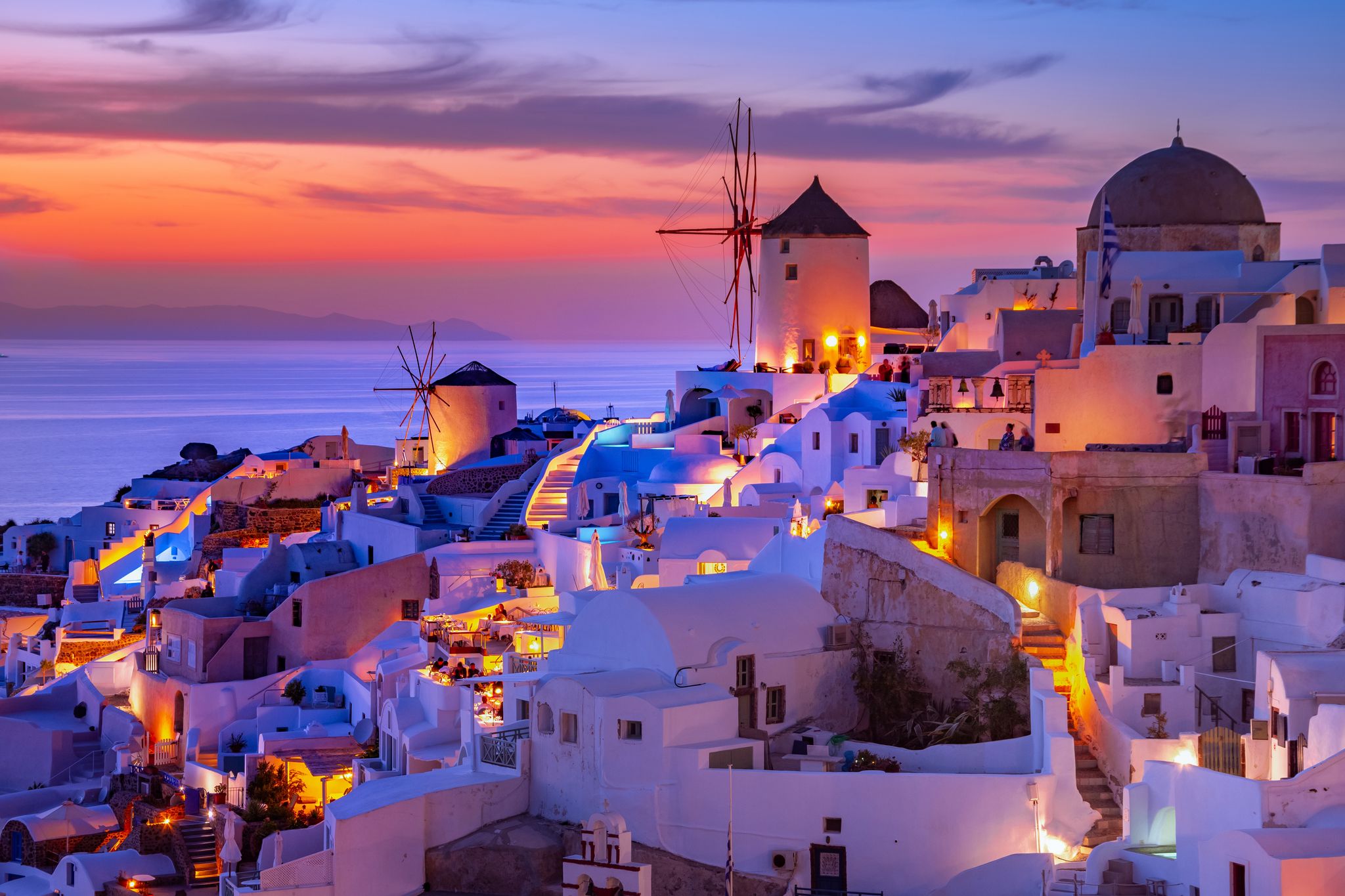 Photo of white architecture on Santorini island with beautiful view on the beach at sunset, Greece.