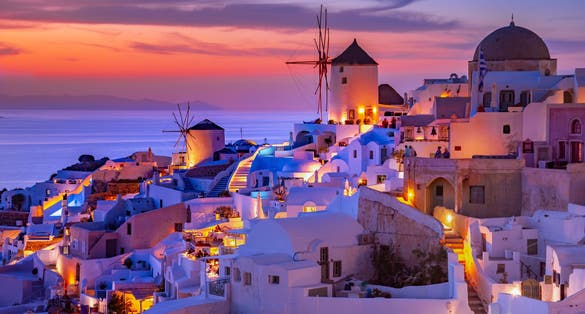 Photo of white architecture on Santorini island with beautiful view on the beach at sunset, Greece.
