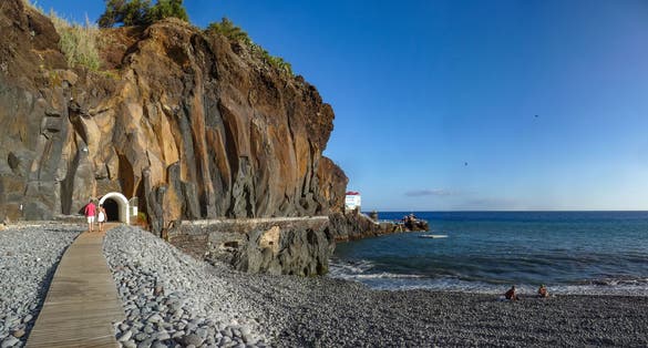 Praia Formosa beach along the Praia Walking Road from Funchal to Câmara de Lobos with the entrace to tunnel - Doca do Cavacas natural pools at Madeira, Portugal
