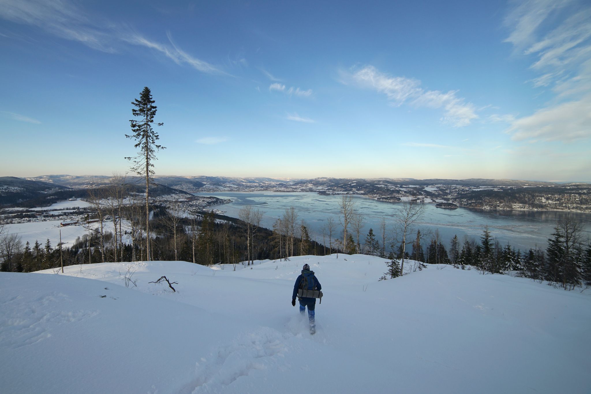 Lonely man walking down on background of Drammen fjord in winter time, Norway.
