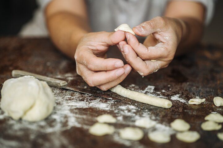 Hands shaping fresh orecchiette pasta during a traditional cooking class in Lecce, Italy..jpg