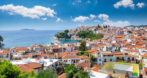 Photo of Skiathos town, beautiful view of the old town with boats in the harbor.