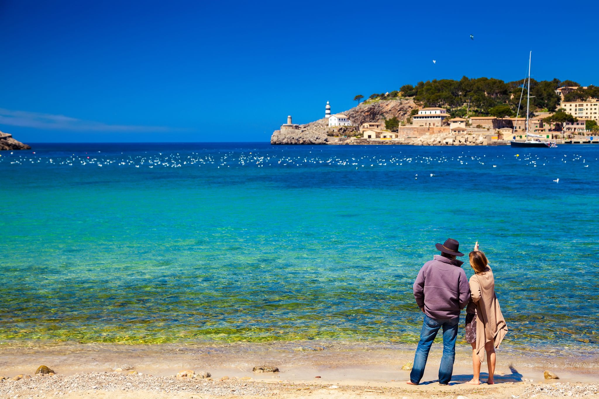 unrecognizable couple enjoying beautiful view of the harbour of Port de Soller, Majorca, Spain