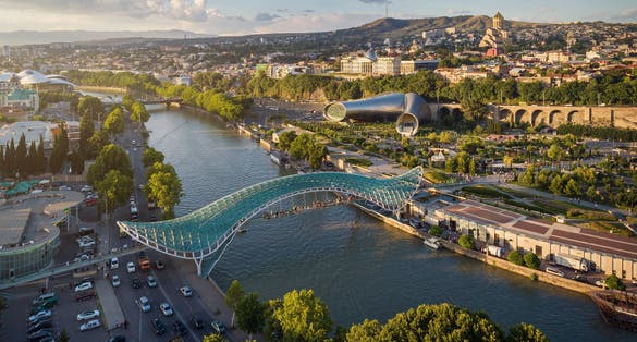 photo of Panoramic aerial view of downtown Tbilisi, Georgia. In the foreground is the Peace Bridge over the Mtkvari River.