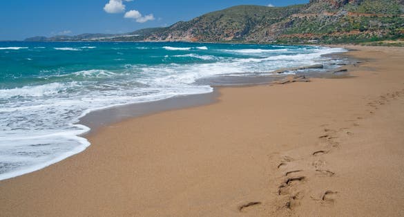 Photo of Agios Nikolaos beach from Crete, Greece. Footprints in the sand.