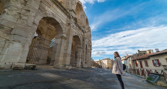 photo of happy tourist visiting Arles Amphitheatre in Arles, France.