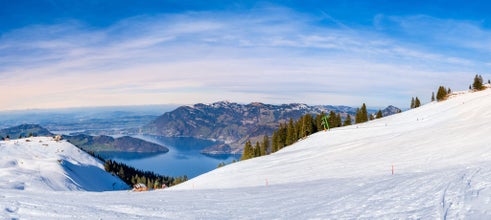 Panorama of Klewenalp mountains and Lake Lucerne or Vierwaldstattersee from mountain peak covered with snow. Popular ski resort in Swiss Alps and winter sport attraction in Switzerland in winter.
