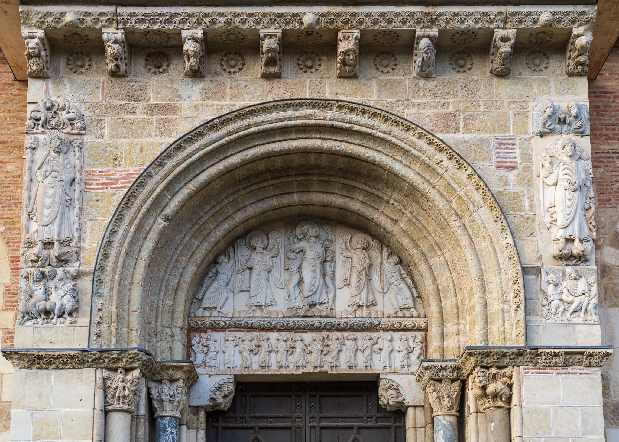 View of the ancient romanesque tympanum representing the Ascension of Christ with angels and the apostles at St Sernin basilica, Toulouse, France