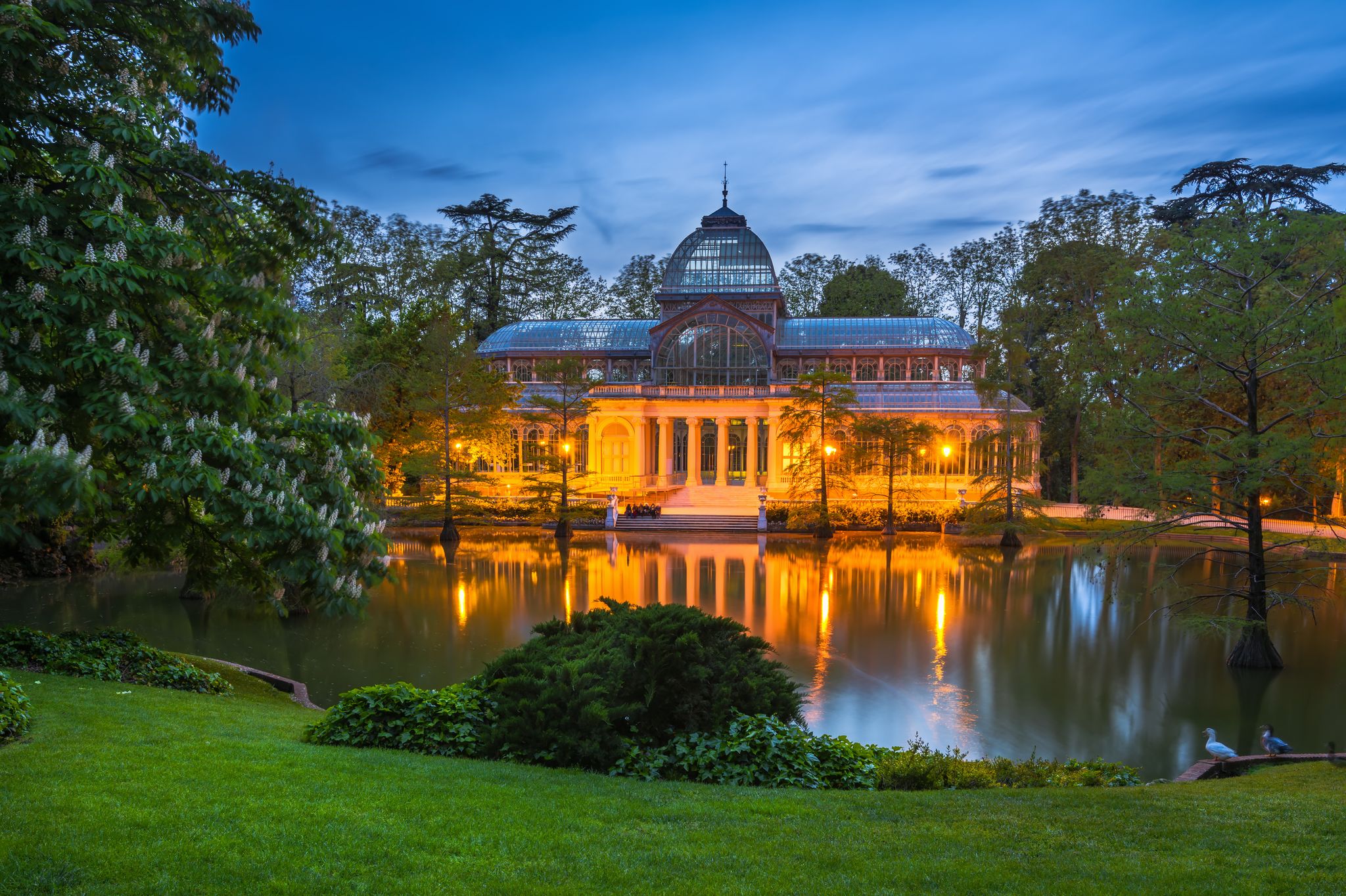 Photo of Crystal Palace (Palacio de cristal) at night in the Retiro Park in Madrid.