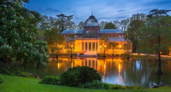 Photo of Crystal Palace (Palacio de cristal) at night in the Retiro Park in Madrid.
