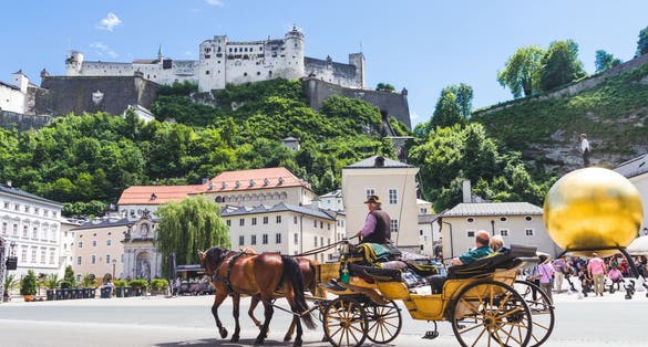 Photo of tourists sightseeing in horse carriage in Salzburg, Austria.