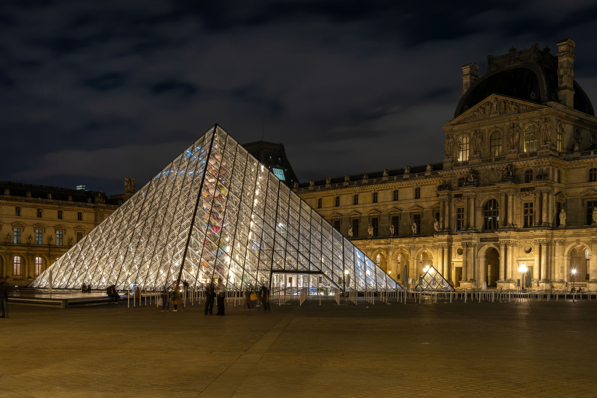 Photo of the Louvre glass pyramid illuminated at night, Paris, France.