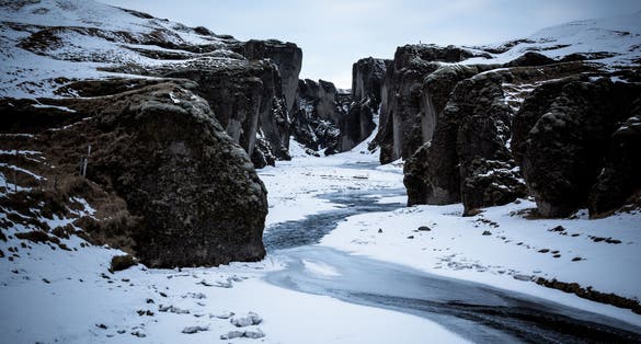 photo of view of Fjaðrárgljúfur canyon covered by snow and ice, Kirkjubæjarklaustur, Iceland.