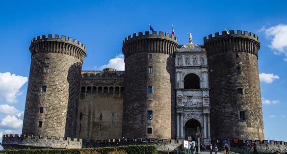 Photo of Maschio Angioino Castle in Naples during a sunny sunrise.