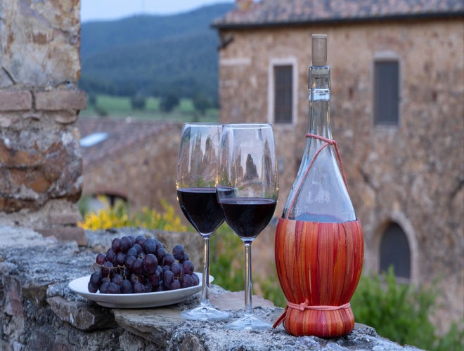 Classic Tuscan wine and grapes set against a rustic countryside backdrop in Italy’s summer season..jpg