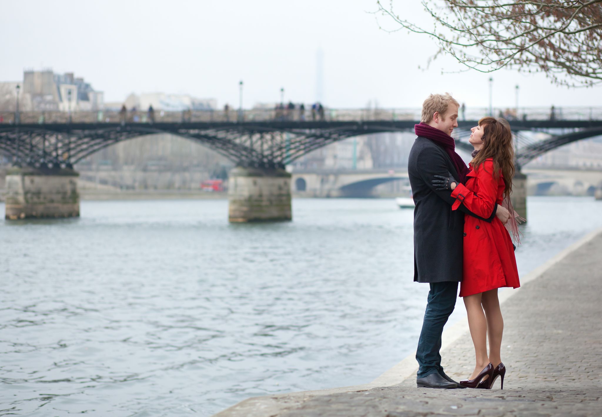 photo of romantic couple in love hugging near Pont des Arts in Paris, France.