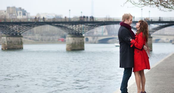 photo of romantic couple in love hugging near Pont des Arts in Paris, France.