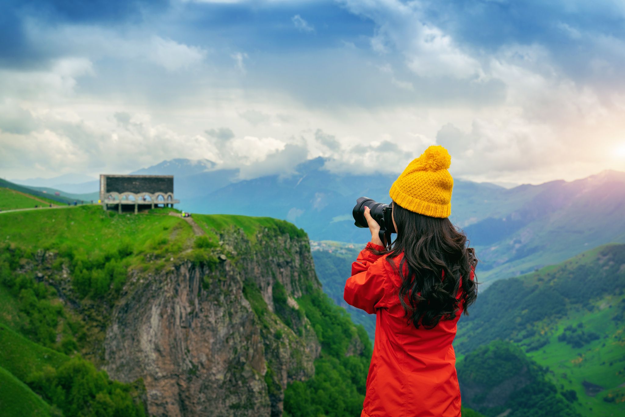 Photo of tourist take a photo near Russia Georgia friendship monument on the georgian military road at the Jvari pass, Georgia.