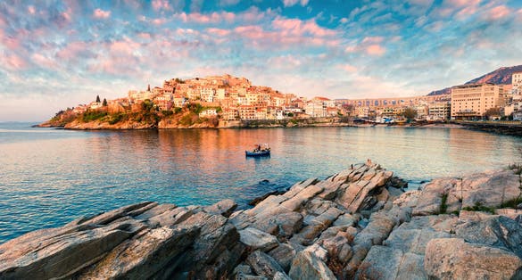 Photo of sunny spring panorama of Aegean Sea. Colorful sunrise in Kavala city.