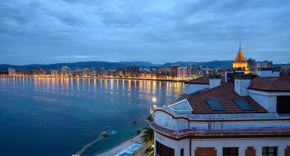 Photo of Evening view on promenade, houses and San Lorenzo beach in Gijon, Asturias, Spain .