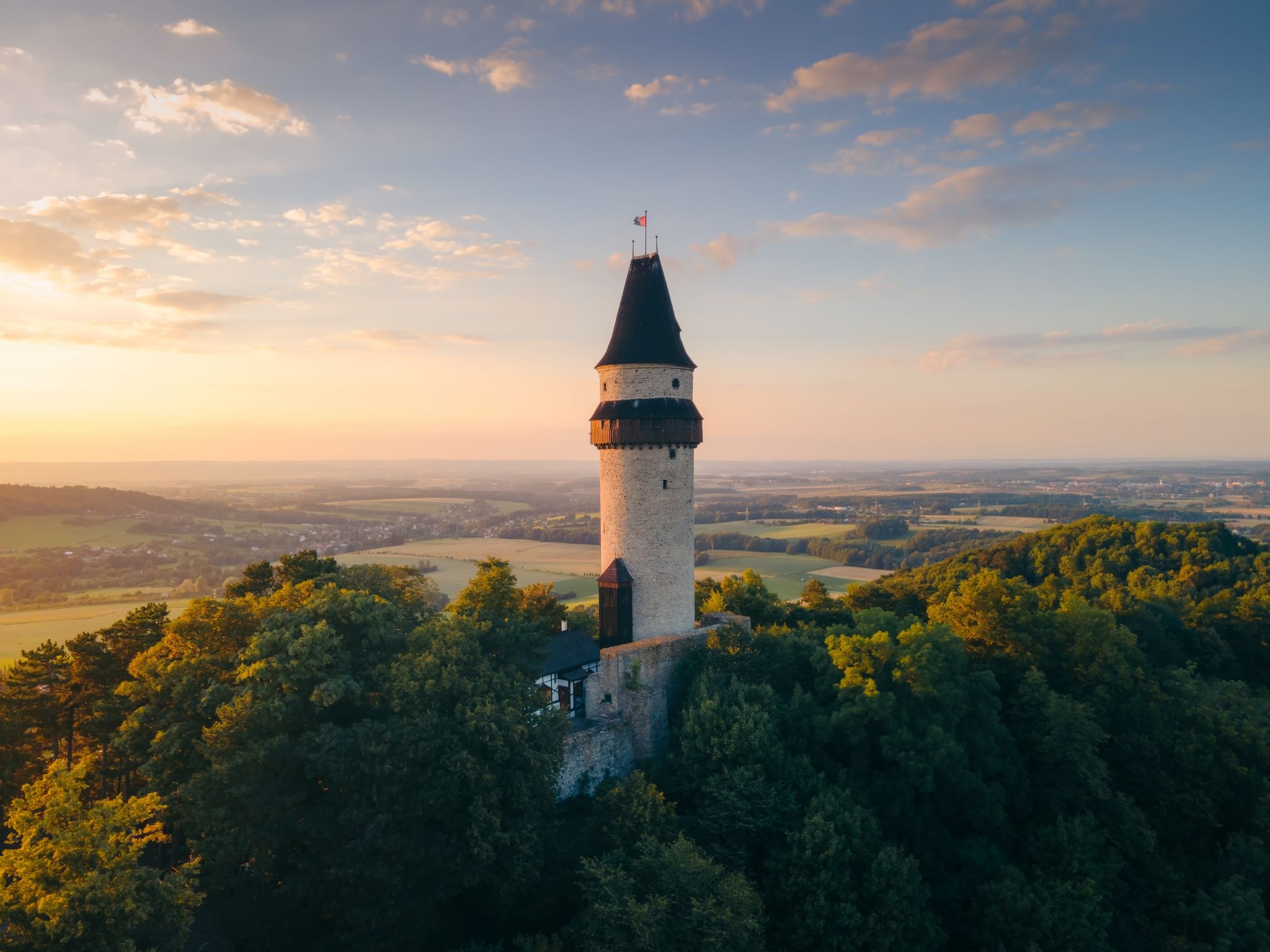 Photo of aerial view of watchtower Stramberska Truba while sunset golden hour in Stramberk in the Czech Republic.