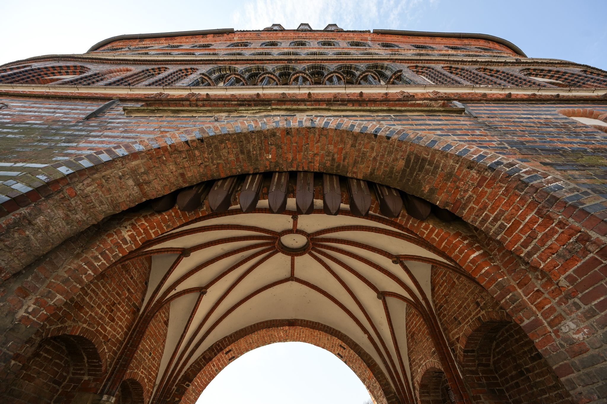 Vault in the entrance arch of the Lubeck Holstentor (Holsten gate), famous historic landmark in gothic brick architecture from medieval times, seen from below on a sunny day