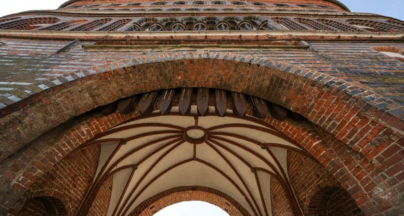 Vault in the entrance arch of the Lubeck Holstentor (Holsten gate), famous historic landmark in gothic brick architecture from medieval times, seen from below on a sunny day