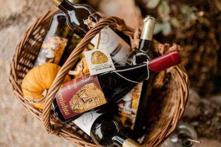 A wicker basket filled with bottles of Macedonian wine and small pumpkins, taken in North Macedonia..jpg