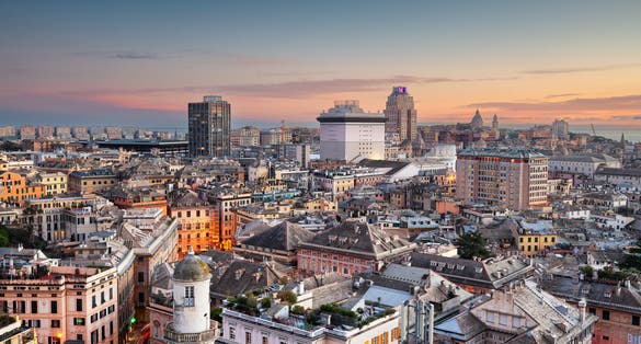 Photo of Genoa, Liguria, Italy downtown city skyline from above at dusk.