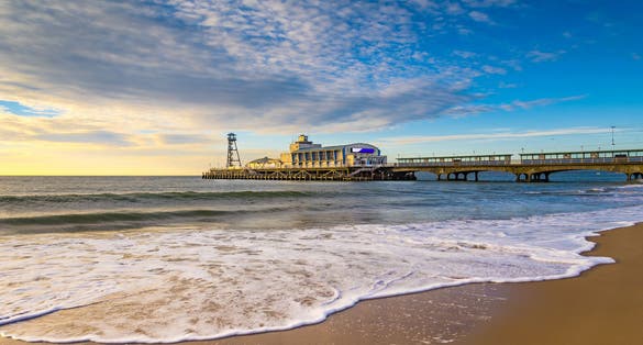 Photo of the sun rises over the sea at Bournemouth illuminating the clouds and the sea.