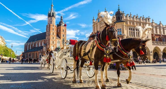 Photo of horse carriages at main square in Krakow in a summer day, Poland.