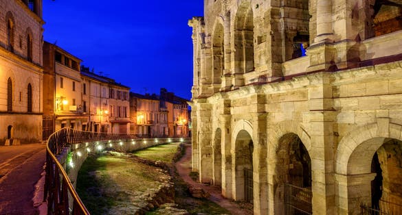photo of Arles Old Town and Roman Arles Amphitheatre at late evening light in Arles, France.