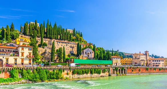 photo of Castel San Pietro St. Peter Castle, Museo Archeologico, Convento di San Girolamo on hill with cypress trees and Adige river in Verona city historical centre, blue sky, Veneto Region, Northern