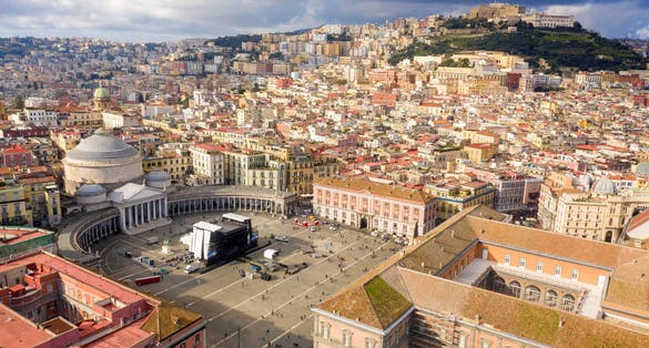 photo of aerial view of piazza del plebiscito, a large public square in the historic center of naples, Italy. It's bounded by san francesco di paola' s church. In background castel sant' elmo and vomero hill.