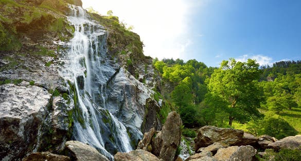 Majestic water cascade of Powerscourt Waterfall, the highest waterfall in Ireland. Famous tourist atractions in co. Wicklow, Ireland.