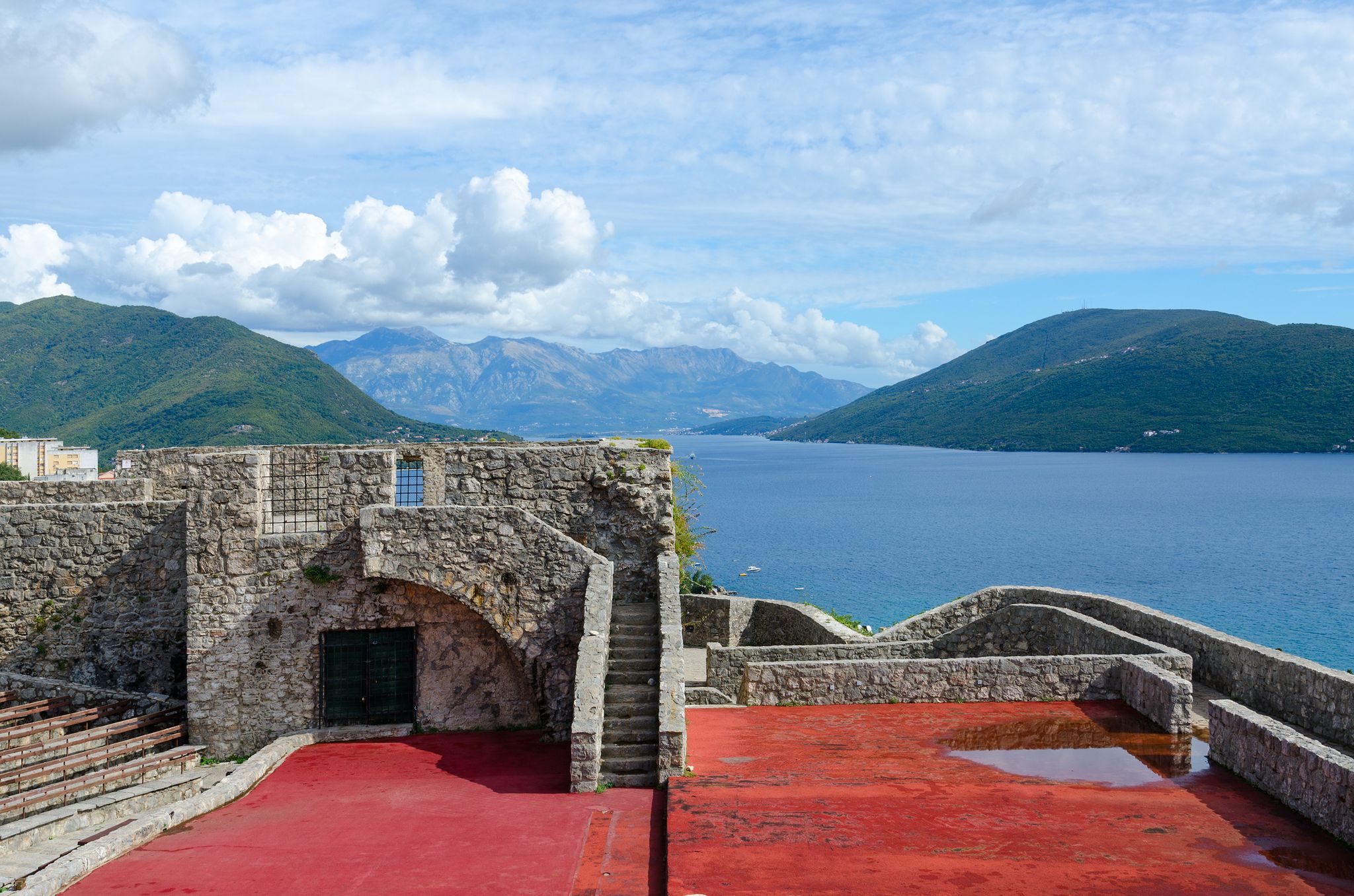 Photo of Fortress Kanli-Kula (Bloody Tower) against backdrop of Bay of Kotor and mountains, Herceg Novi, Montenegro.