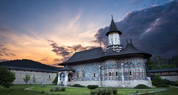 Photo of Sucevita Monastery in Romania at sunset.