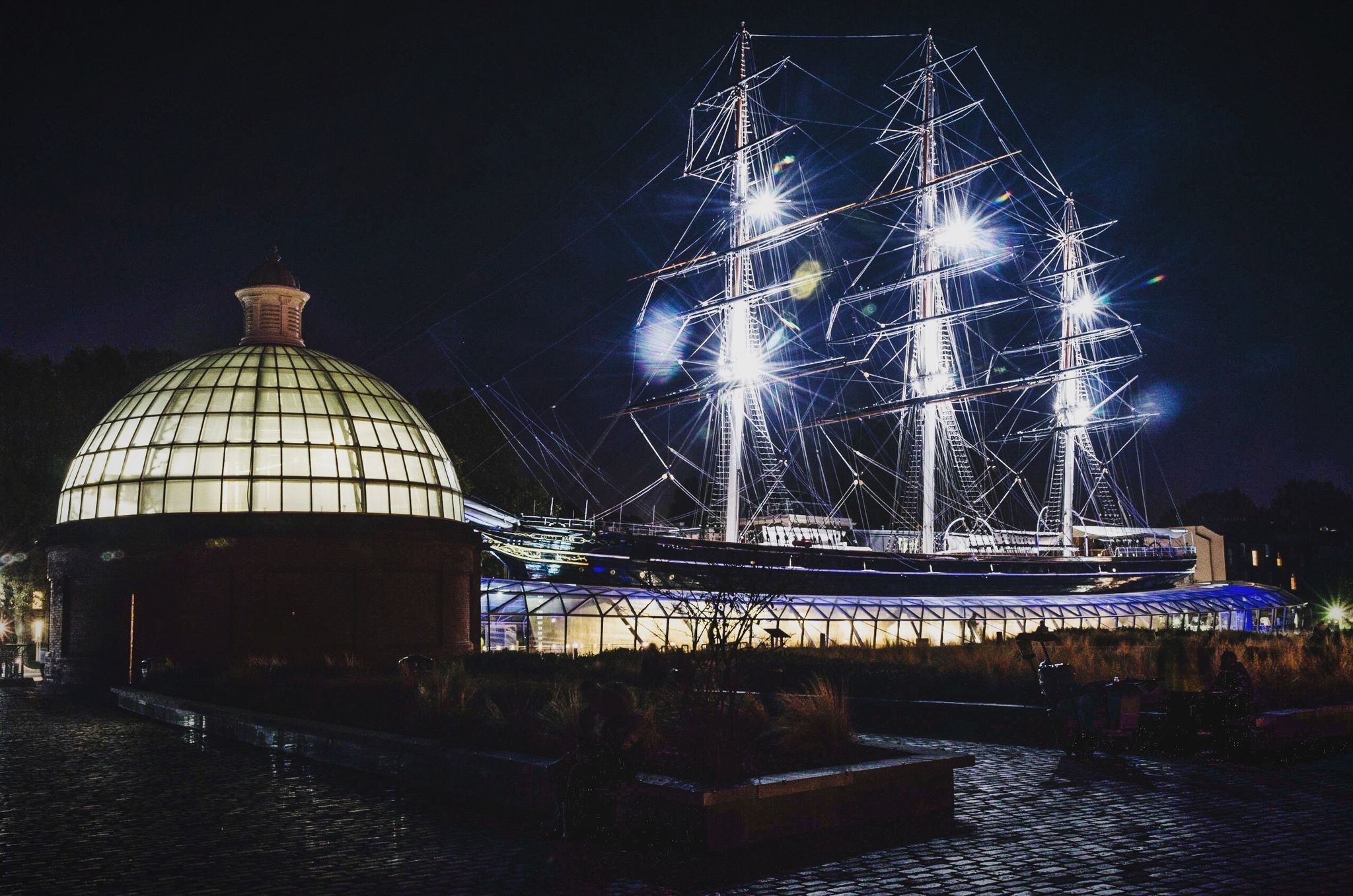 Photo of Cutty Sark illuminated at night, Greenwich, London, UK.