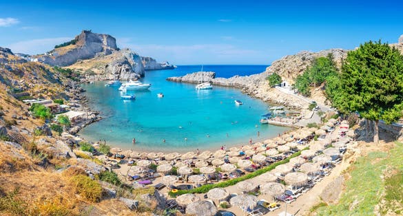 Photo of panoramic aerial view of St. Paul bay with acropolis of Lindos in background ,Rhodes, Greece.