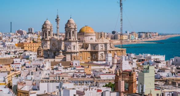 photo of rooftops of houses in aerial view of the medieval city of Cádiz and towers and Cathedral Cádiz in seafront, Spain.