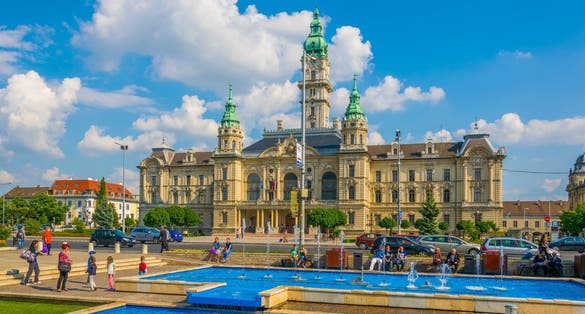 People are sitting around a singing fountain situated in front of the town hall in the hungarian city Gyor.