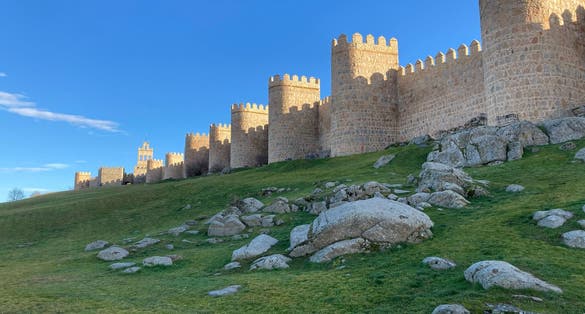 photo of view of Ávila, Spain, is a city in the rolling hill country northwest of Madrid. It’s best known for its intact medieval city walls, with 80-plus crenelated, semicircular towers and 9 gates.