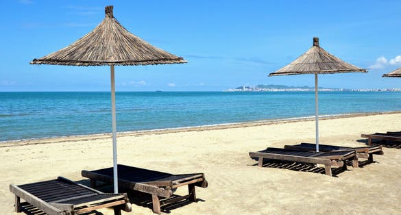 Umbrella and chaise lounges on white sand beach in Durres ,Albania.