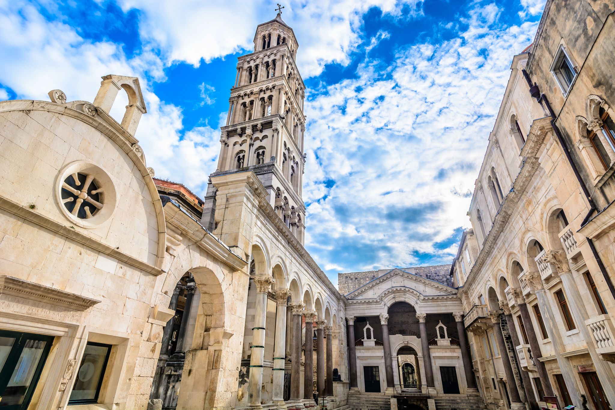 Photo of marble ancient roman architecture in city center of town Split, view at square Peristil in front of cathedral Saint Domnius and bell tower landmarks, Croatia.