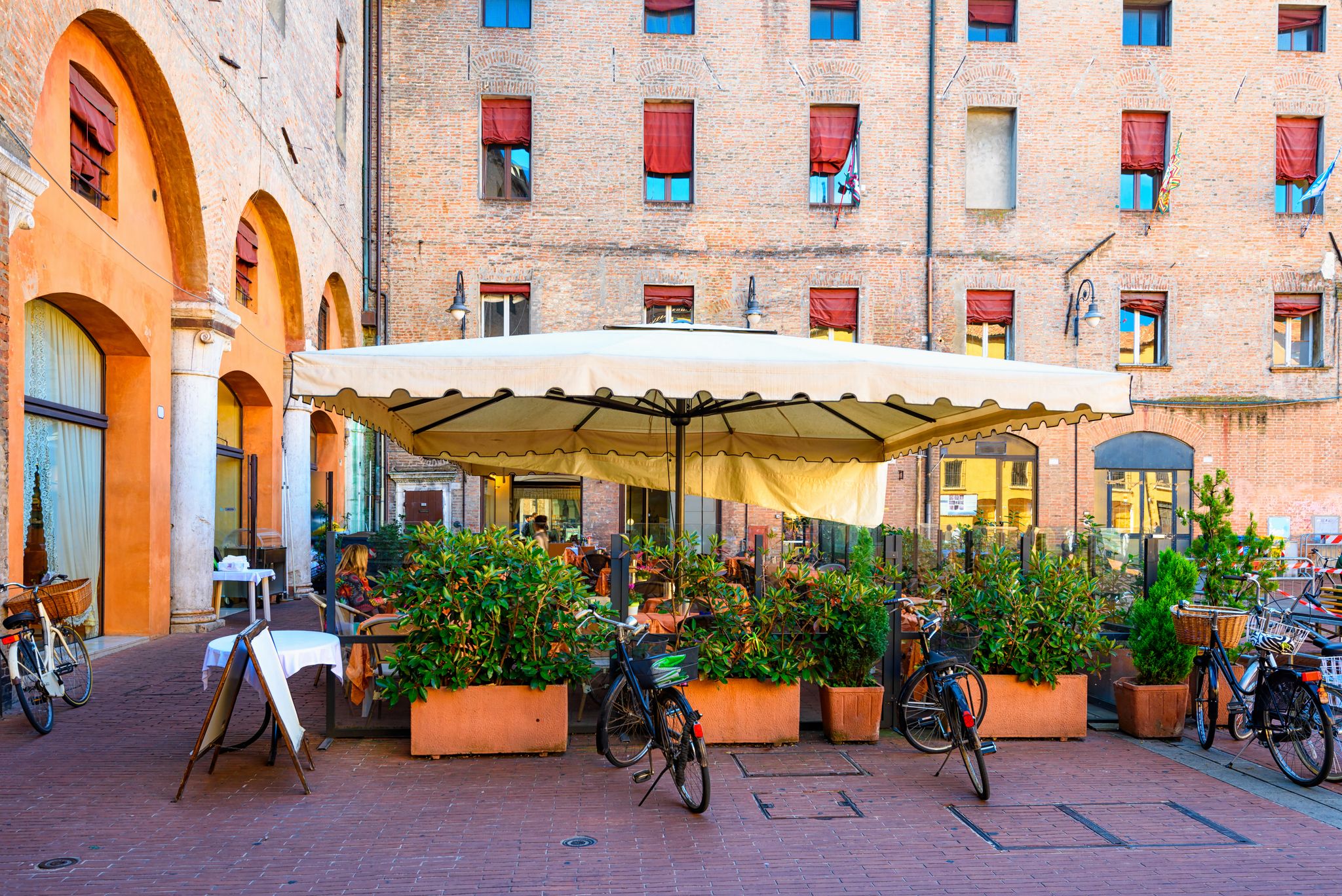 Piazza del Municipio with tables of restaurant in Ferrara, Emilia-Romagna, Italy. Ferrara is capital of the Province of Ferrara.
