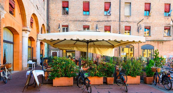 Piazza del Municipio with tables of restaurant in Ferrara, Emilia-Romagna, Italy. Ferrara is capital of the Province of Ferrara.