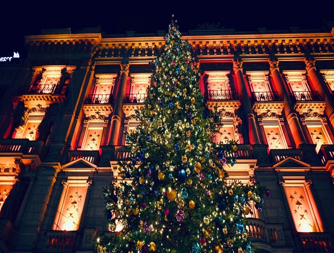 Giant Christmas tree lit up in front of a grand building during December in Switzerland..jpg
